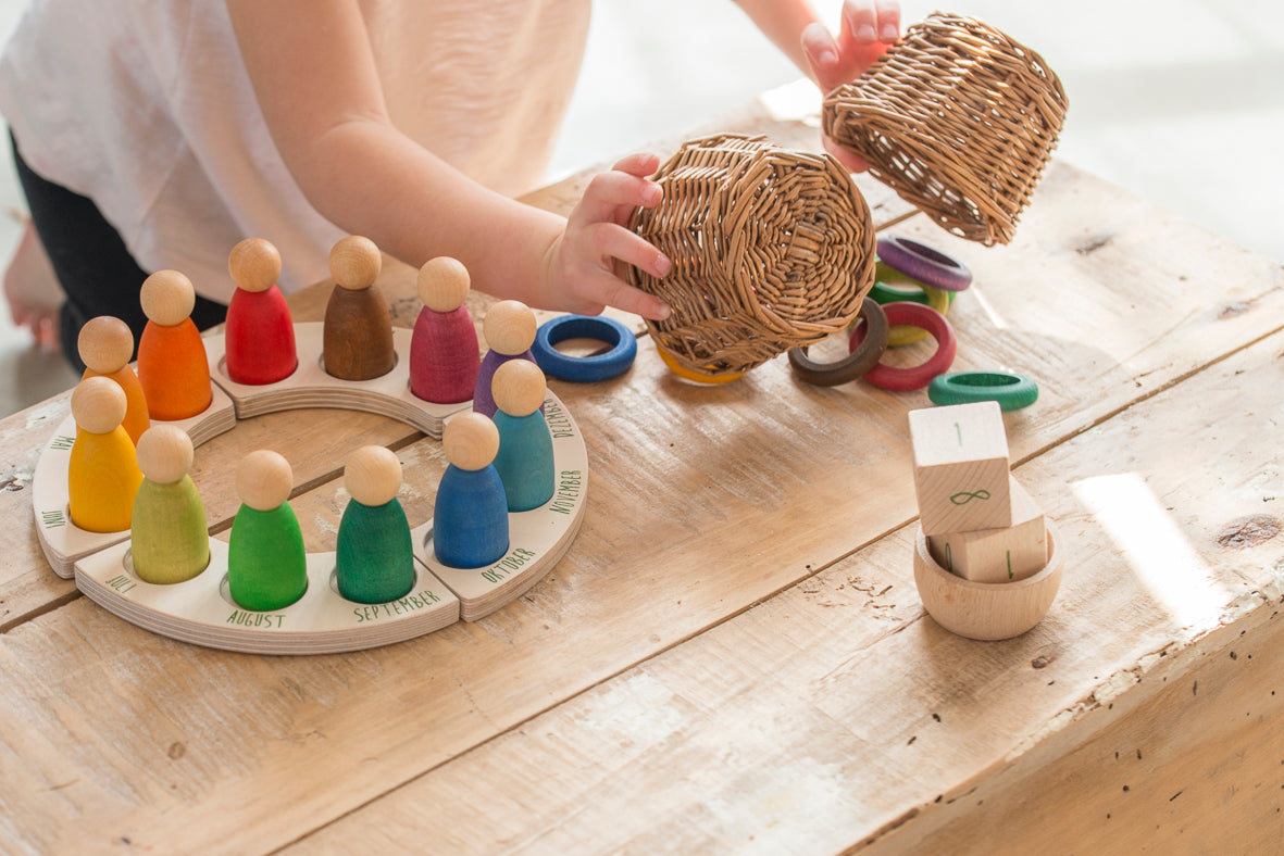 A kid playing with the perpetual calendar and 12 ring set