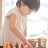 A kid standing, playing with the perpetual calendar and 12 ring set