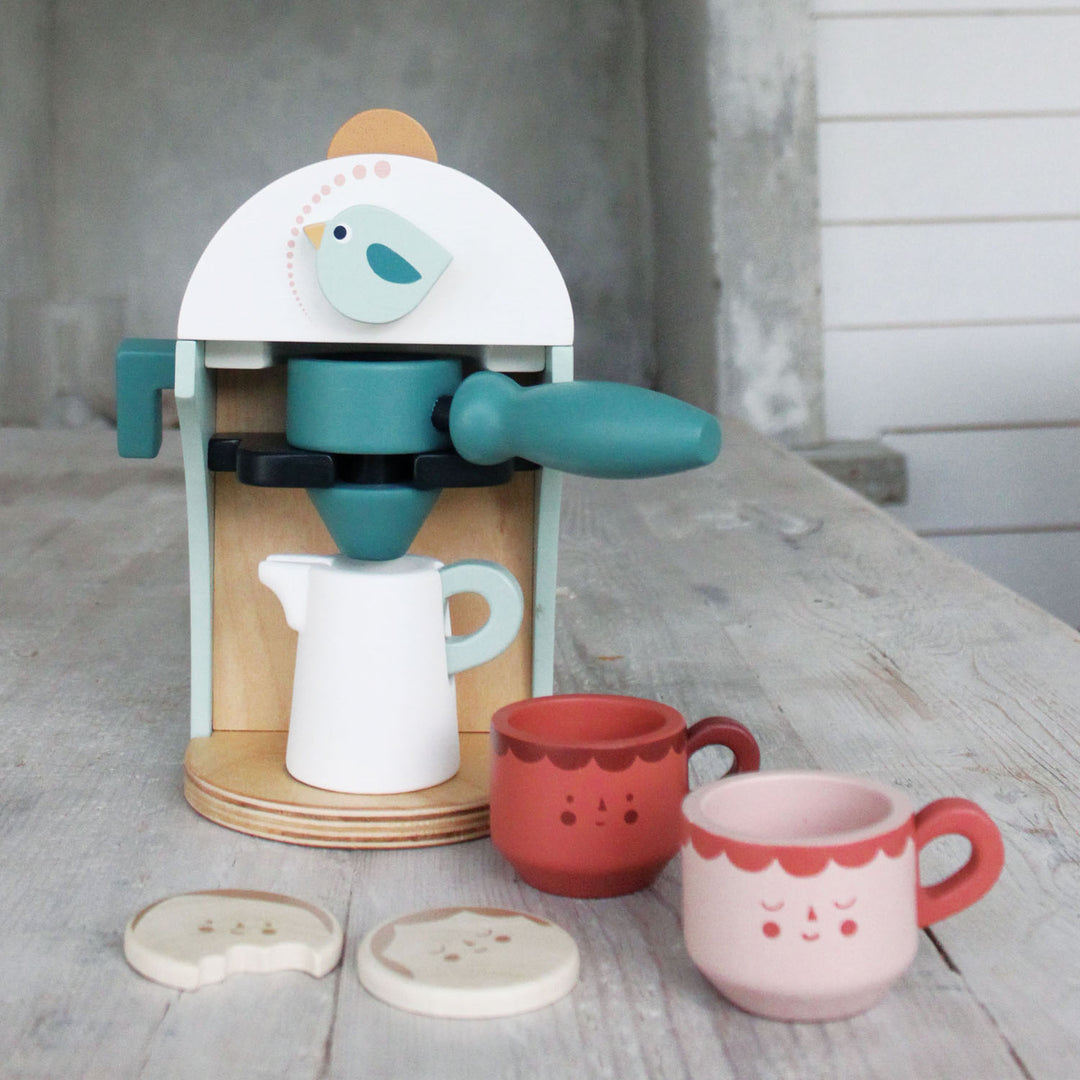 A play/wooden espresso machine with pretend coffee filling a milk frother